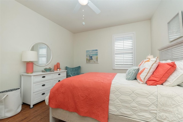 bedroom with multiple windows, dark wood-type flooring, and ceiling fan