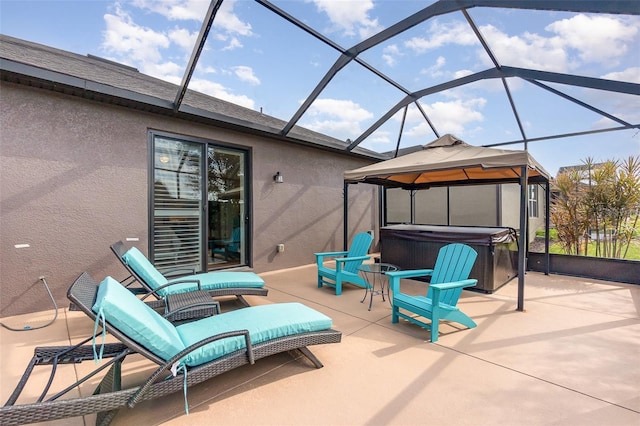 view of patio / terrace featuring a hot tub, a gazebo, and glass enclosure