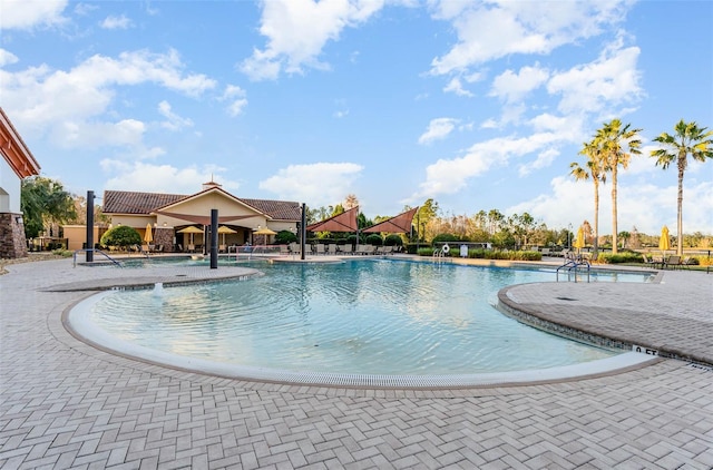 view of pool with pool water feature and a patio