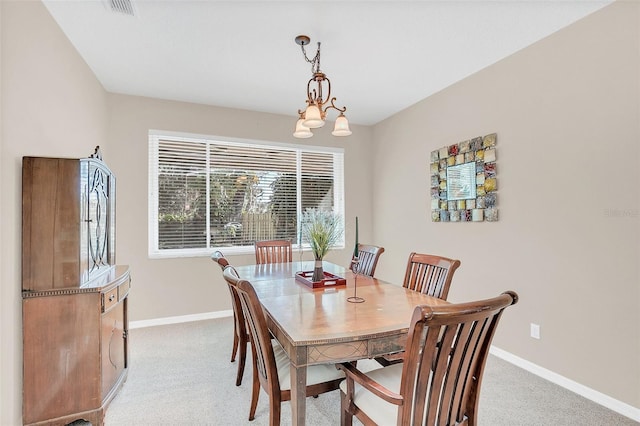 dining area featuring an inviting chandelier and light carpet