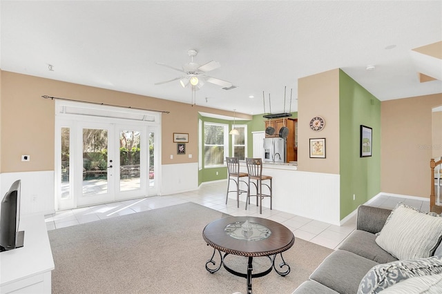 living room featuring light tile patterned flooring, ceiling fan, and french doors