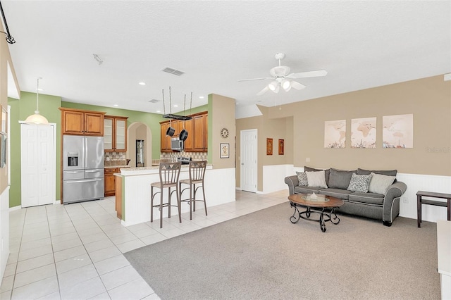 living room with light tile patterned floors, a textured ceiling, and ceiling fan