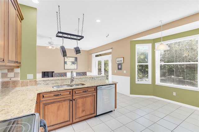 kitchen with sink, decorative light fixtures, light tile patterned floors, dishwasher, and stove