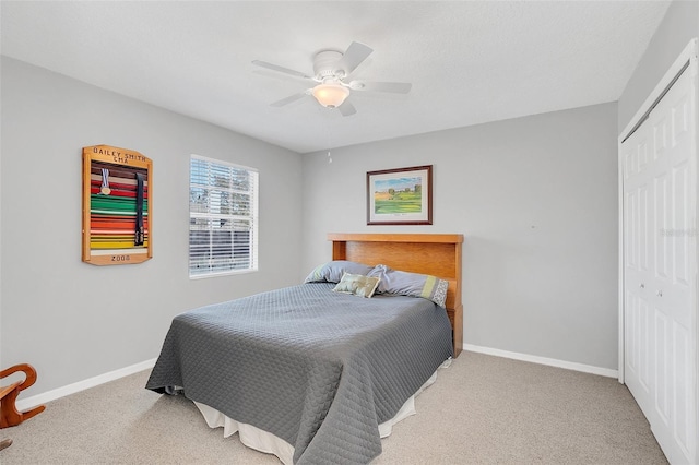 carpeted bedroom with ceiling fan and a closet