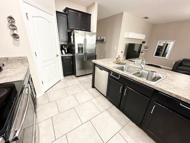 kitchen featuring light tile patterned flooring, appliances with stainless steel finishes, and sink