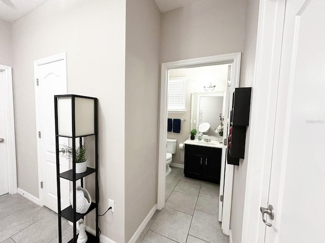 corridor with light tile patterned floors and sink