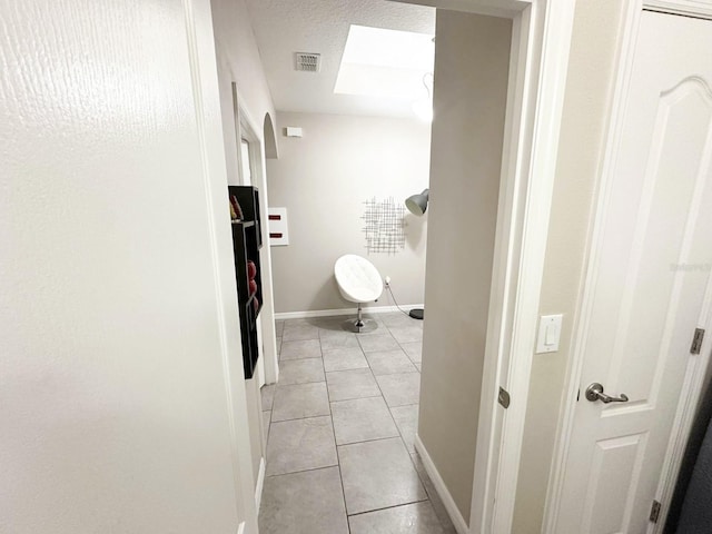 hall featuring light tile patterned floors