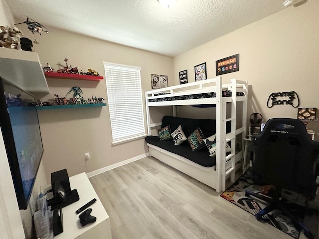 bedroom featuring a textured ceiling and light hardwood / wood-style flooring