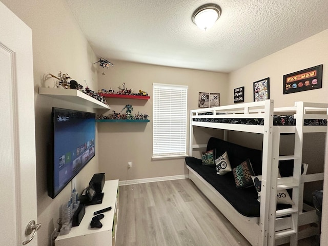 bedroom with light hardwood / wood-style floors and a textured ceiling