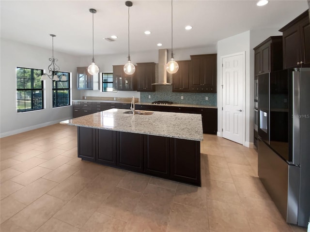 kitchen with sink, dark brown cabinets, stainless steel appliances, ventilation hood, and a center island with sink