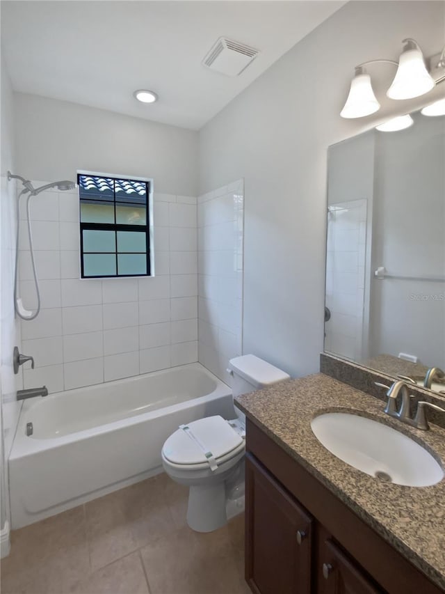 full bathroom featuring tile patterned flooring, vanity, tiled shower / bath, and toilet