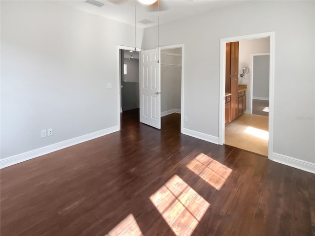 unfurnished bedroom with dark hardwood / wood-style flooring, a closet, and a spacious closet