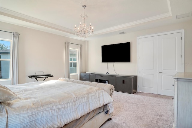 carpeted bedroom featuring ornamental molding, a tray ceiling, a closet, and visible vents