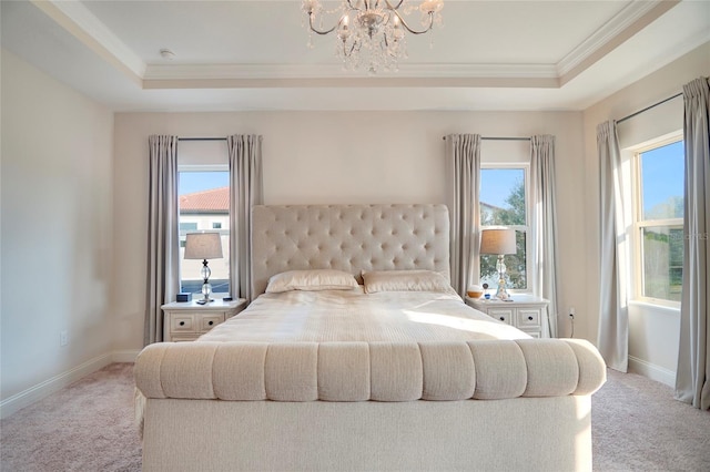 carpeted bedroom featuring baseboards, multiple windows, and a tray ceiling