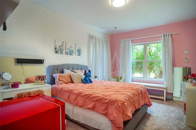 carpeted bedroom with brick wall