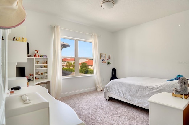 bedroom featuring baseboards and light colored carpet