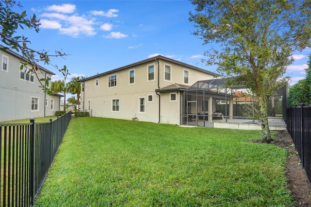 back of house featuring a yard and a lanai