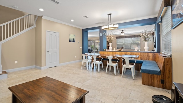 dining room with crown molding and ceiling fan with notable chandelier