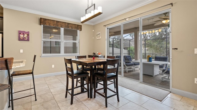 dining space with ornamental molding, ceiling fan with notable chandelier, and light tile patterned flooring