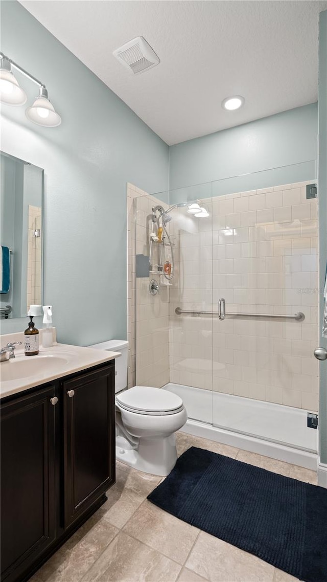 bathroom featuring vanity, an enclosed shower, and toilet