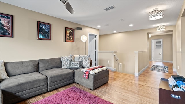 living room featuring ceiling fan and light hardwood / wood-style flooring