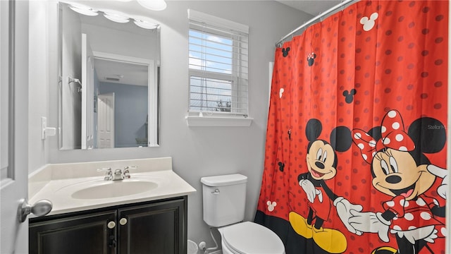 bathroom featuring vanity, toilet, and curtained shower