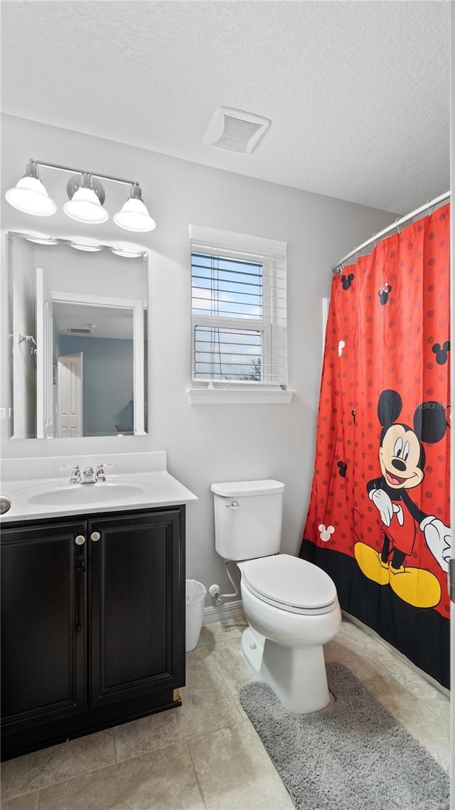 bathroom with vanity, a textured ceiling, and toilet