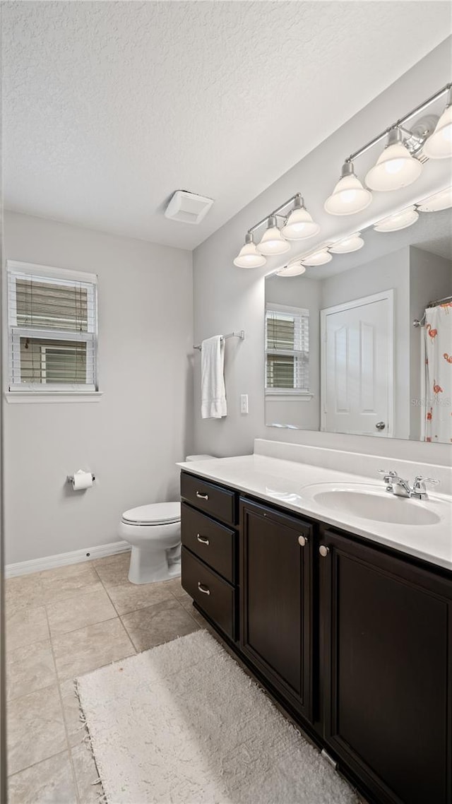 bathroom with tile patterned flooring, vanity, a textured ceiling, curtained shower, and toilet