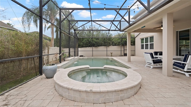 view of swimming pool featuring an in ground hot tub, ceiling fan, glass enclosure, and a patio