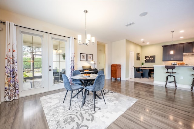 dining space featuring a notable chandelier, dark hardwood / wood-style flooring, and french doors