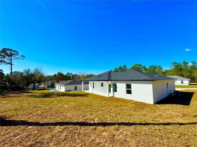 rear view of property featuring a lawn