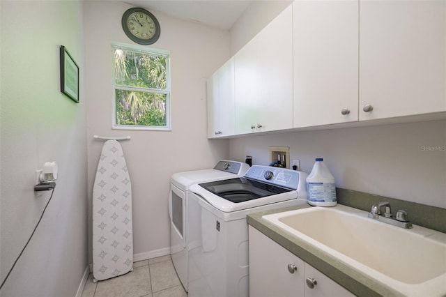 clothes washing area featuring cabinets, sink, light tile patterned floors, and independent washer and dryer