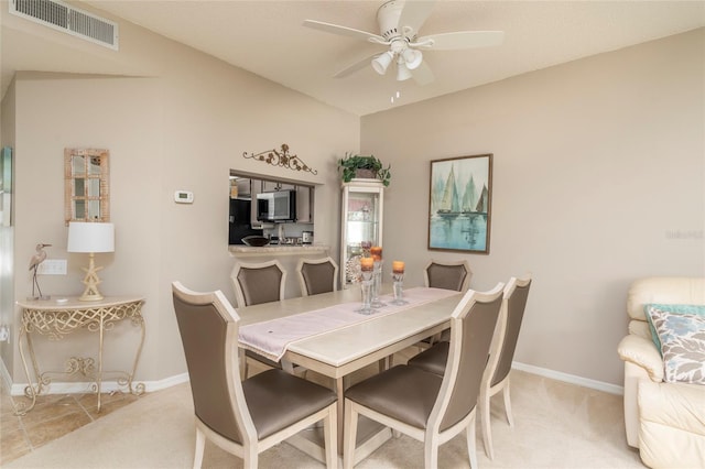 carpeted dining area with ceiling fan