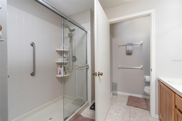 bathroom with tile patterned flooring, vanity, walk in shower, and toilet