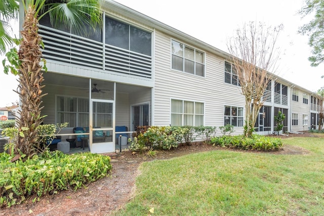 back of property with a lawn and ceiling fan