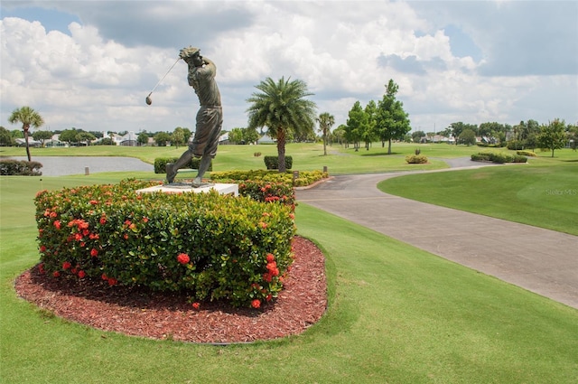 surrounding community featuring a water view and a lawn