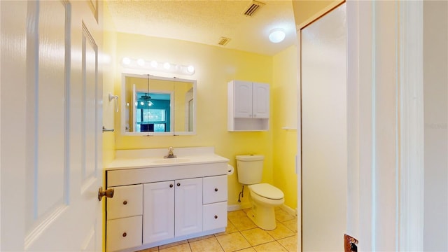 bathroom featuring vanity, tile patterned flooring, toilet, and a textured ceiling