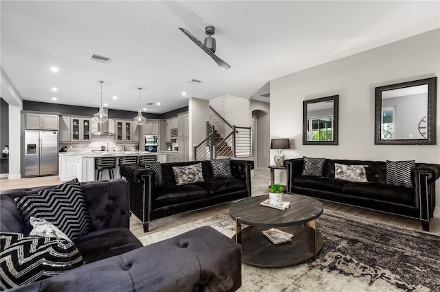 living room with wood-type flooring and ceiling fan