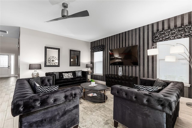 living room with ceiling fan, plenty of natural light, and light wood-type flooring