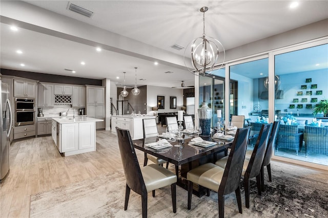 dining room with a chandelier and light wood-type flooring