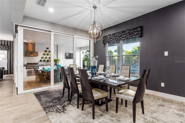 dining space featuring hardwood / wood-style floors and a notable chandelier