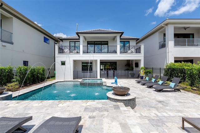 view of swimming pool with an in ground hot tub, pool water feature, and a patio