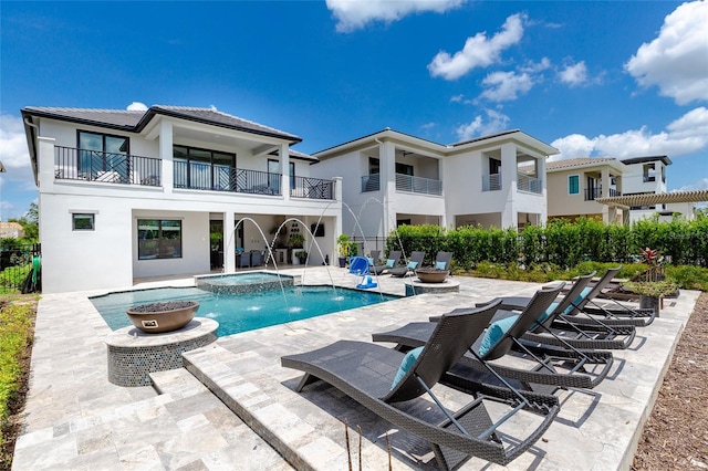 view of pool featuring a patio area, pool water feature, and an in ground hot tub