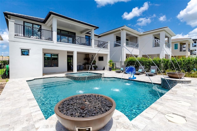 view of pool featuring pool water feature, an in ground hot tub, and a patio