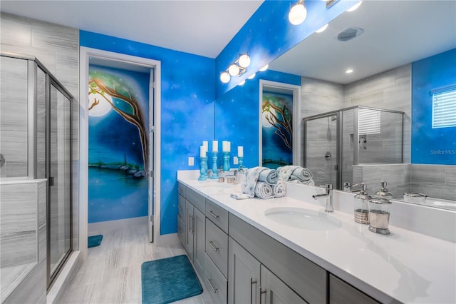 bathroom with a shower with door and vanity