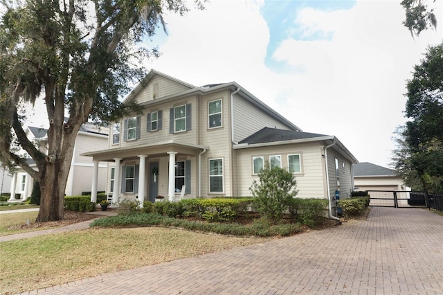 view of front of property with a garage, a front lawn, and covered porch