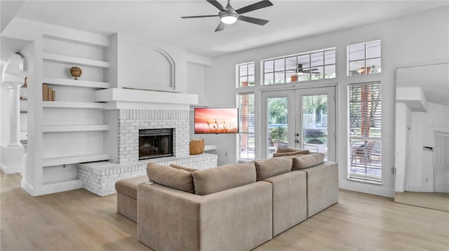 living room with light hardwood / wood-style flooring, a wealth of natural light, and built in features