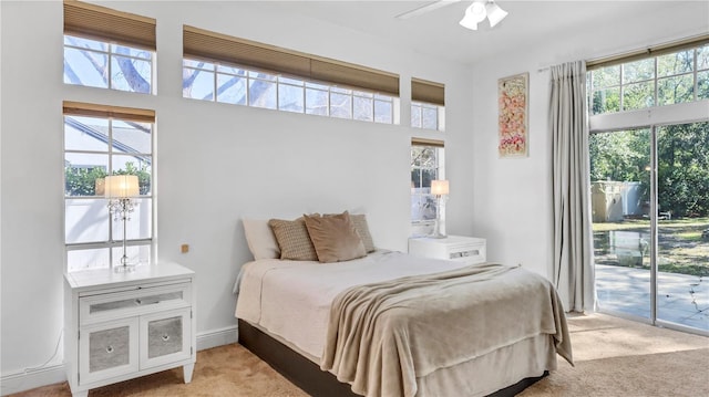 bedroom featuring light carpet, access to exterior, and ceiling fan