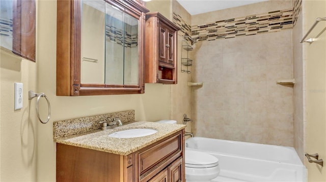 full bathroom featuring tiled shower / bath, vanity, and toilet