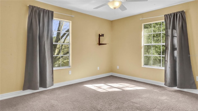 carpeted spare room featuring ceiling fan